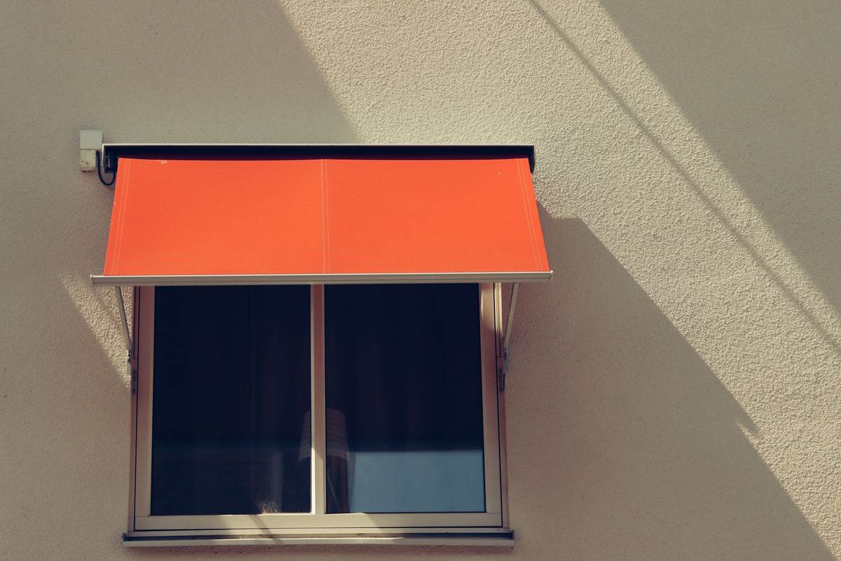 Un store extérieur déployé pour filtrer le soleil devant une façade vitrée