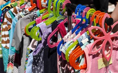Enfants en magasin, vêtements colorés sur cintres variés